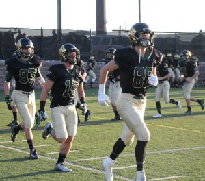 Kellen Parker, Cooper Gale and Kole Cohen run into the stadium to begin warmups.